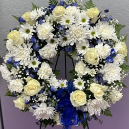 Heart-shaped floral wreath with white roses, daisies, and blue flowers