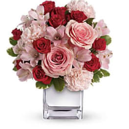 Pink and red rose bouquet in a clear square vase