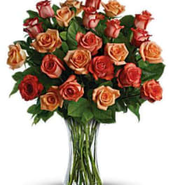 Bouquet of peach and red roses in a clear glass vase
