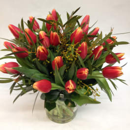 Bouquet of red and yellow tulips in a clear glass vase