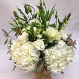 White hydrangeas and roses in a woven basket with tall green buds