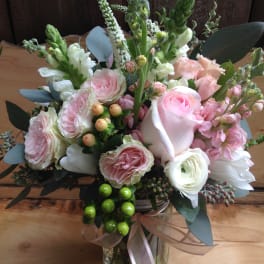 Pink and white bouquet in a glass vase with ribbon