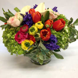 Colorful mixed flower arrangement in a clear glass vase