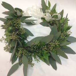 Green foliage wreath with a white ribbon bow