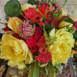 Bouquet of yellow peonies, red gerbera daisies, and pink flowers