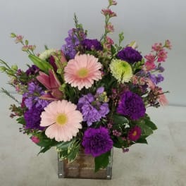 Mixed bouquet with pink gerbera daisies and purple flowers in a wooden box
