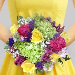 Person holding a colorful bouquet of mixed flowers