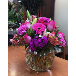 Pink and purple mixed bouquet in a round glass vase