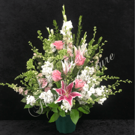Pink roses and a lily in a vase with white flowers