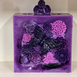 Purple decorative candle with butterfly and flower reliefs