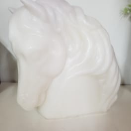 White unicorn-shaped candle with a molded mane and horn