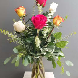 Bouquet of multicolored roses in a clear glass vase