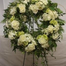 White rose and hydrangea wreath on a black stand