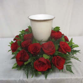 Red roses arranged around a white urn vase