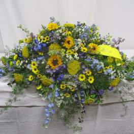 Large mixed floral spray with yellow and blue flowers on a table