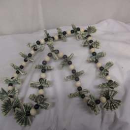 Beaded garland with folded dollar bills on a white cloth