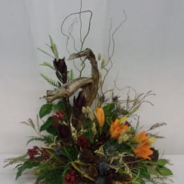 Autumn floral arrangement with orange blooms, berries, and driftwood