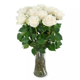 White roses arranged in a clear glass vase