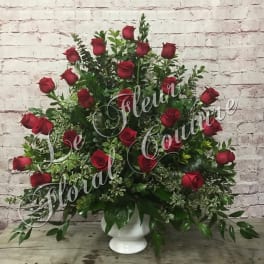 Red roses arranged in a white pedestal vase