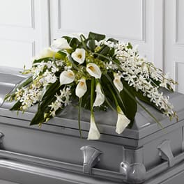 White floral casket spray with calla lilies and orchids