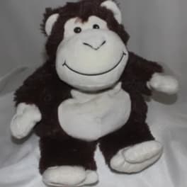 Plush monkey toy with a smiling face and white hands and feet