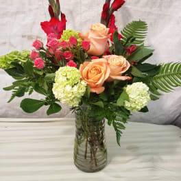 Mixed bouquet of peach and pink roses in a glass vase