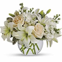 White lilies and cream roses arranged in a round vase