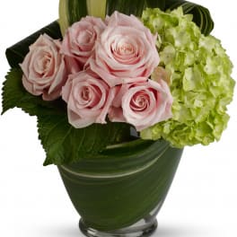 Pink roses and green hydrangea in a glass vase