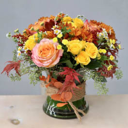 Autumn bouquet of roses and daisies in a glass vase