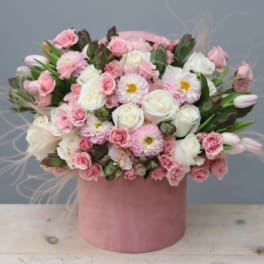 Round pink hatbox arrangement of soft pink and white roses, dahlias, carnations, and tulips