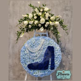 Blue floral standing spray with a high-heel shoe design and white flowers on top