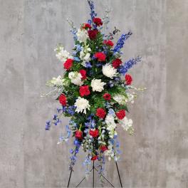 Tall standing floral spray with red, white, and blue flowers