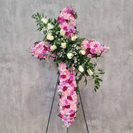 Large floral cross on a stand with pink and white roses