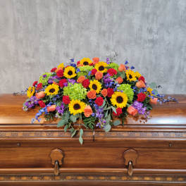 Colorful floral spray on a wooden casket