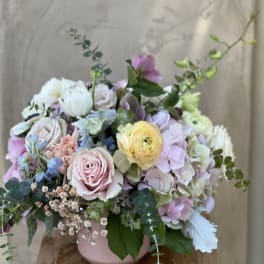Pastel bouquet in a pink vase with roses, hydrangeas, and ranunculus