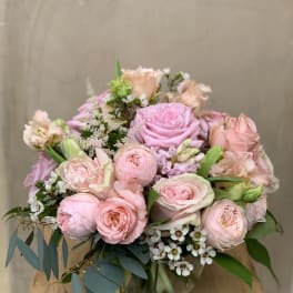 Pink roses and blush flowers arranged in a glass vase