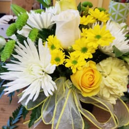 Yellow and white bouquet with roses, daisies, and a ribbon bow