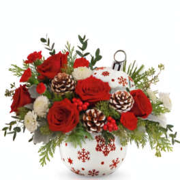 Red roses and white flowers arranged in a snowflake ornament vase