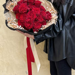 Large bouquet of red roses with baby's breath wrapped in black paper
