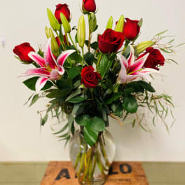 Red roses and pink lilies in a clear glass vase