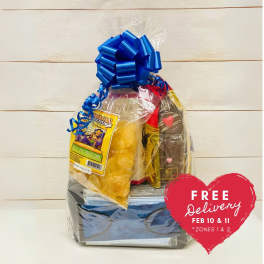 Snack gift basket wrapped in clear cellophane with blue bow and assorted chips and chocolates