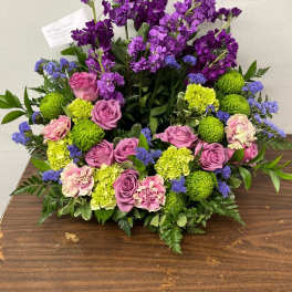 Purple and pink floral arrangement with green blooms on a table