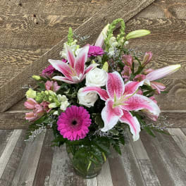 Pink lilies and gerbera daisies in a glass vase
