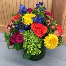 Colorful mixed flower arrangement in a dark vase