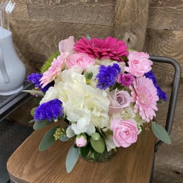 Pink and white mixed flower arrangement in a glass vase