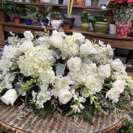 Large white floral arrangement with roses, hydrangeas, and daisies