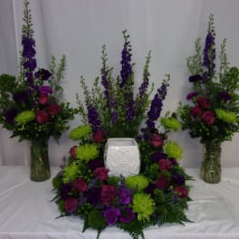 Purple and green floral funeral set with a white urn in the center