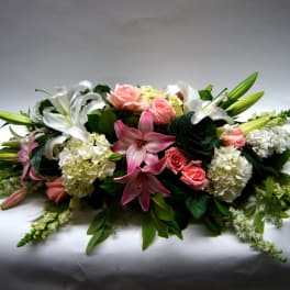 Low floral centerpiece with pink roses, white lilies, and hydrangeas