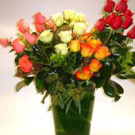 Bouquet of multicolored roses in a tall glass vase