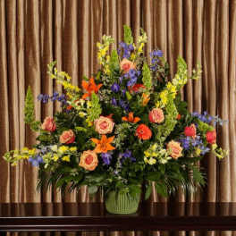 Large mixed flower arrangement in a green vase